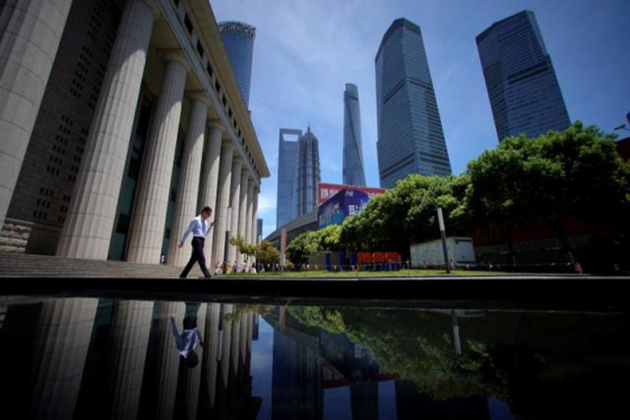 A man walking at Lujiazui financial district of Pudong in Shanghai, China 	— Reuters