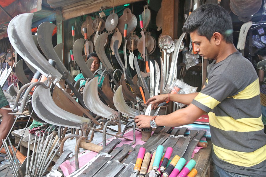 A customer buying knives at a shop at Karwanbazar in the city 	—  FE Photo