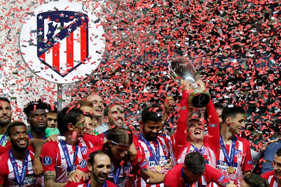 Atletico Madrid's Antoine Griezmann celebrates with the trophy after winning the Super Cup — Reuters