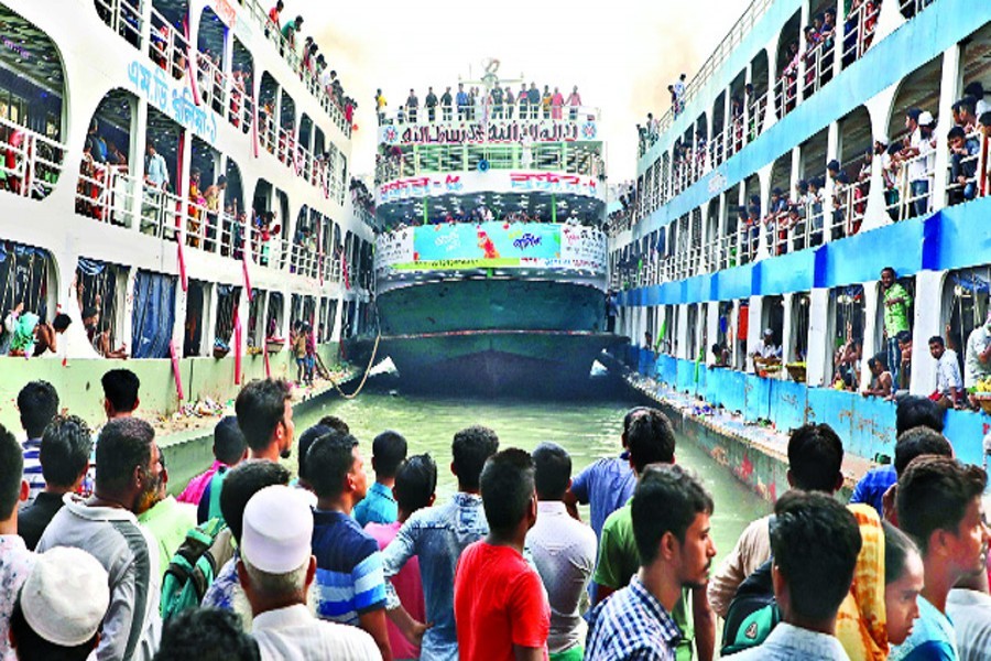 Homebound people looking on as a lunch is squeezing between two others to berth in a dangerous manner at the Sadarghat terminal in the city on Saturday — FE photo by Shafiqul Alam