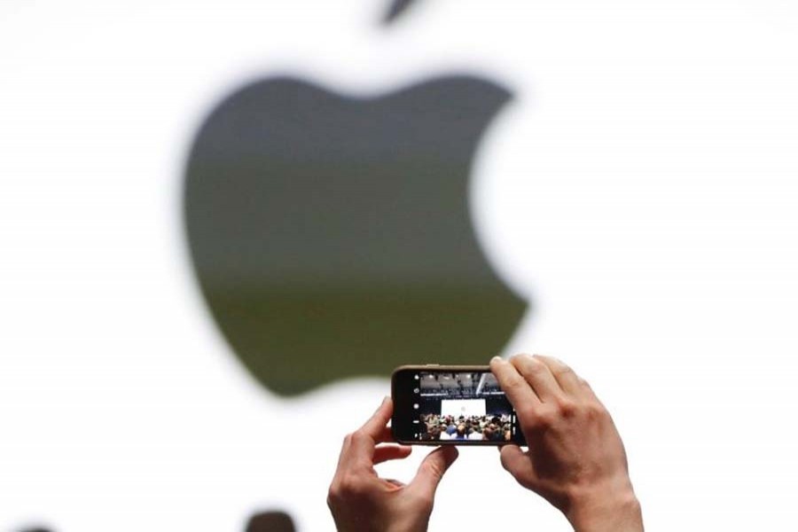 An audience member takes a photo of the Apple logo before the start of the company's annual developer conference in San Jose, California, US June 5, 2017. Reuters/File photo