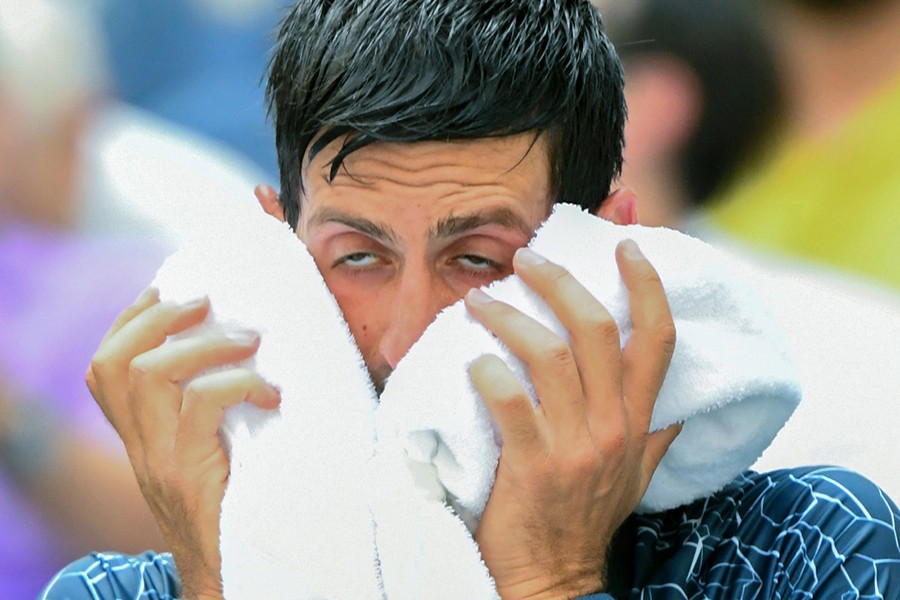 Novak Djokovic of Serbia copes with the extreme heat while playing Marton Fucsovics of Hungary in a first round match on day two of the 2018 US Open tennis tournament at USTA Billie Jean King National Tennis Center on Tuesday — USA Today photo via Reuters