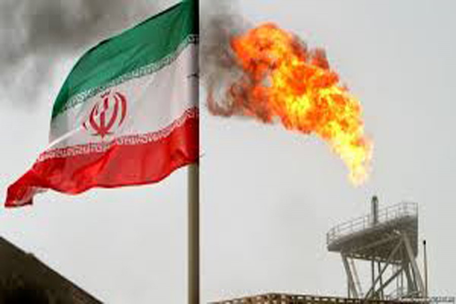 A gas flare on an oil production platform in the Soroush oilfields is seen alongside an Iranian flag in Iran 	— Reuters