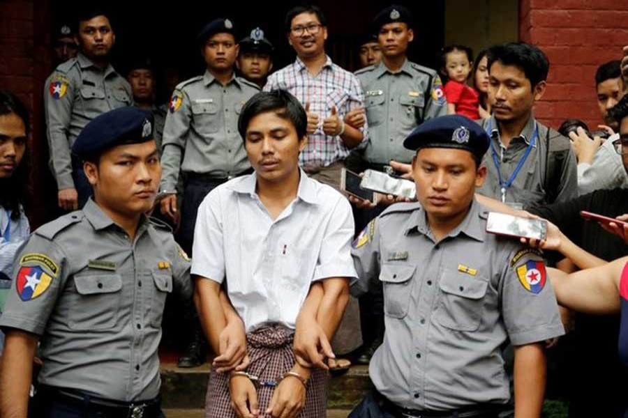 Detained Reuters journalist Kyaw Soe Oo and Wa Lone are escorted by police as they leave after a court hearing in Yangon, Myanmar, August 20, 2018. Reuters/File Photo