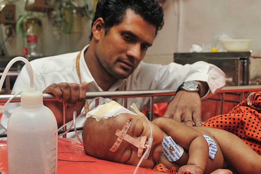 Mohamad Chisti with an infant patient. Photo: Collected