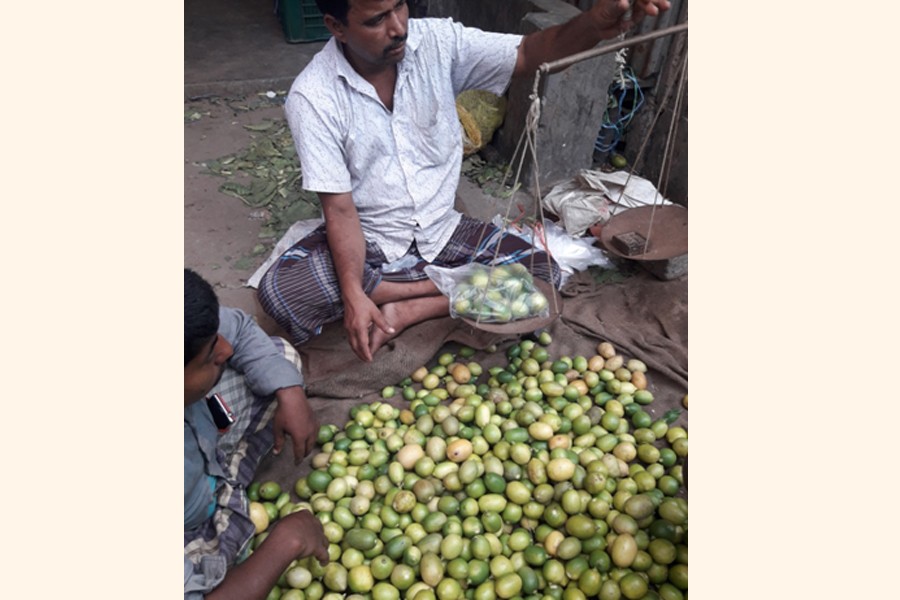 A vendor selling lemon at a wholesale market in Tangail on Monday   	— FE Photo