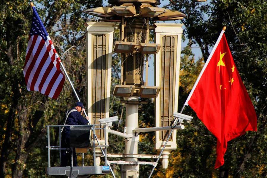 A worker places US and China flags near the Forbidden City ahead of a visit by US President Donald Trump to Beijing, in Beijing, China, November 8, 2017. Reuters/File Photo