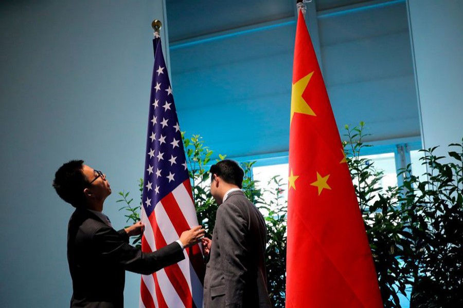 Chinese officials preparing the flags for the China-US bilateral meeting at the G20 leaders summit in Hamburg, Germany 	— Reuters