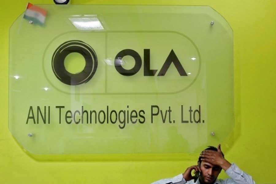 An employee speaks over his phone as he sits at the front desk inside the office of Ola cab service in Gurugram, previously known as Gurgaon, on the outskirts of New Delhi, India, April 20, 2016. Reuters/Files