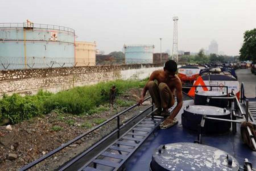 A man cleans an oil tanker parked outside a Hindustan Petroleum fuel depot in Mumbai, October 6, 2017. Reuters/File Photo