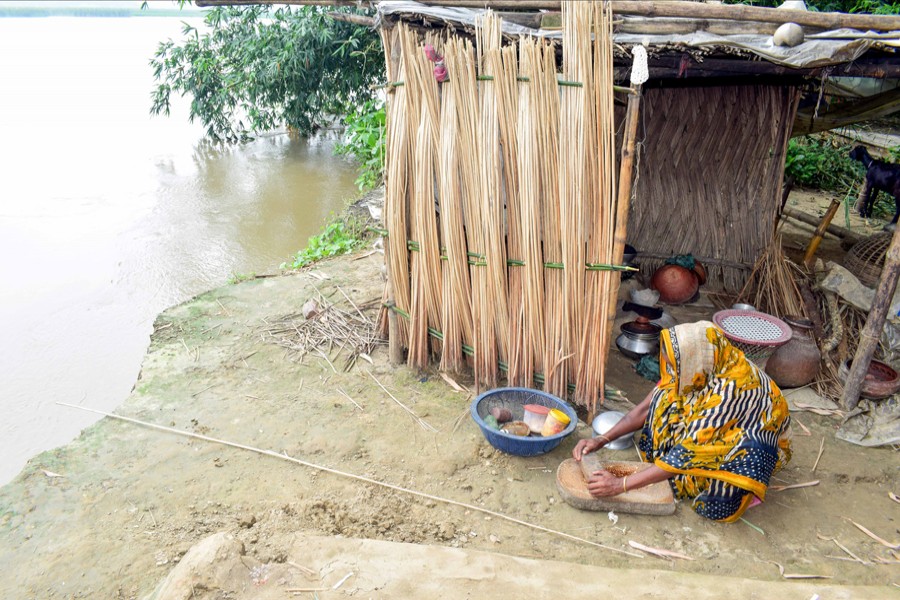 A woman cooking for family members along the riverside even at the risk of erosion in Mohammadpur of Magura 	— FE Photo