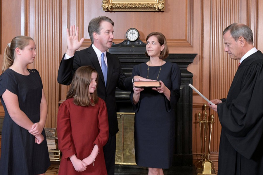 Judge Brett Kavanaugh is sworn in as an Associate Justice of the US Supreme Court by Chief Justice John Roberts as Kavanaugh's wife Ashley holds the family bible and his daughters Liza and Margaret look on in a handout photo provided by the US Supreme Court taken at the Supreme Court building in Washington, US, October 6, 2018. Fred Schilling/Collection of the Supreme Court of the United States/Handout via Reuters