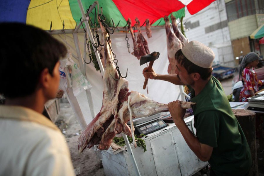 An Uighur vendor cuts meat at a street market in Kashgar, Xinjiang province August 3, 2011 – Reuters file photo