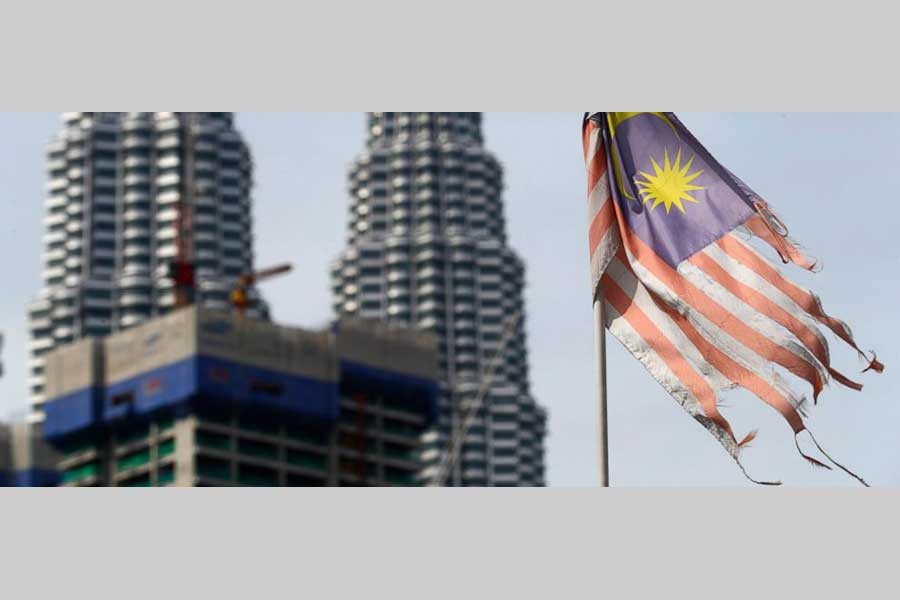 In this April 10, 2018, a battered Malaysian national flag flies in front of the Petronas Towers in Kuala Lumpur, Malaysia. Malaysia's government says it will abolish the death penalty and halt all executions, in a rare move against capital punishment in Asia hailed by human rights groups. - AP Photo