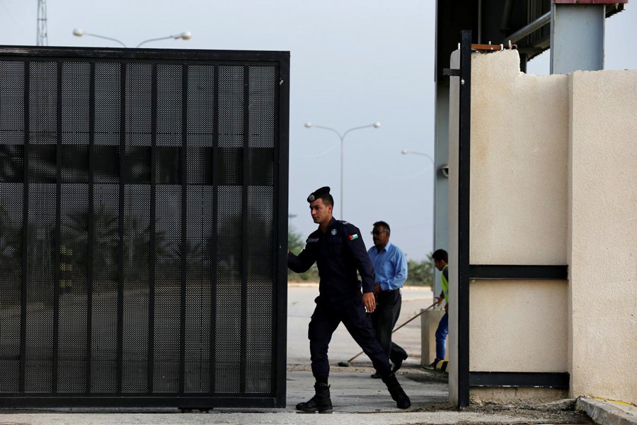 A Jordanian policeman opening the gate of Jordan's Jaber border crossing checkpoint near Syria's Nasib checkpoint, near Marfaq, Jordan on Monday	— Reuters