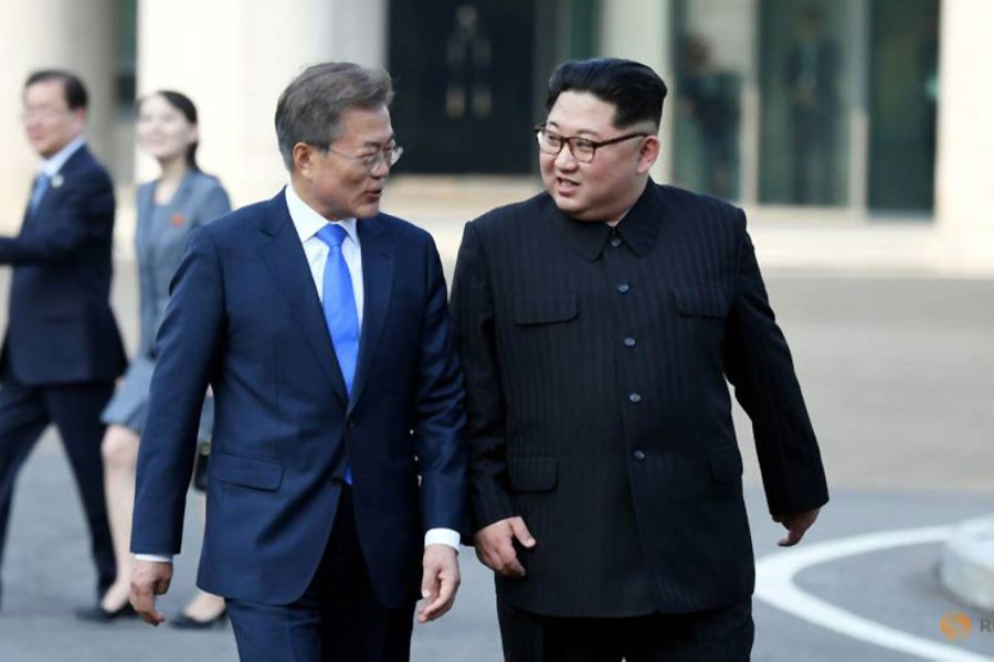 South Korean President Moon Jae-in and North Korean leader Kim Jong Un walk together at the truce village of Panmunjom inside the demilitarized zone separating the two Koreas, South Korea, April 27, 2018 - Reuters