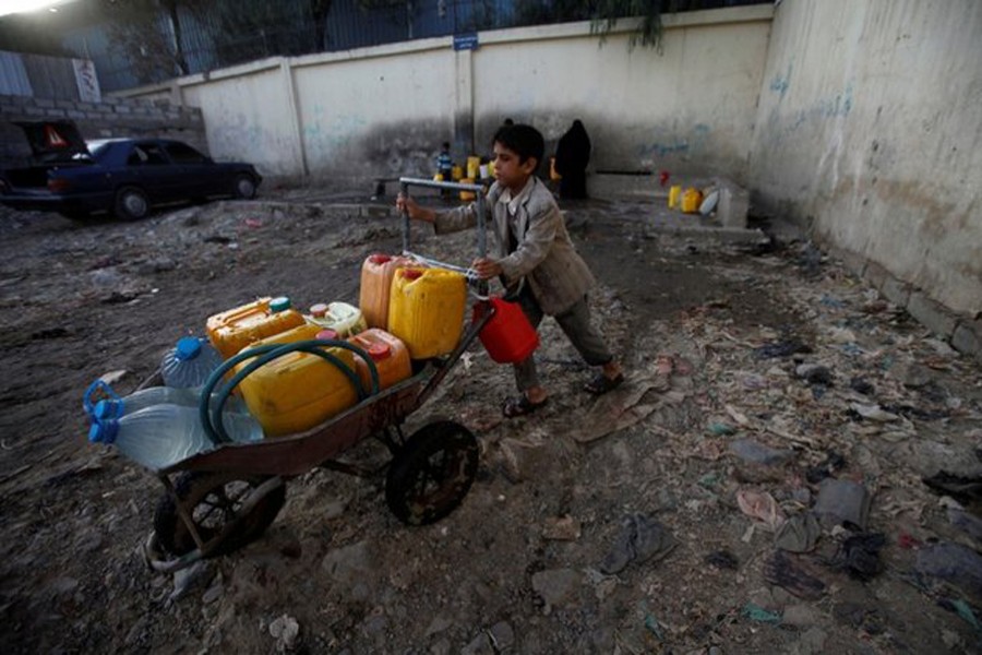 A boy pushes a wheelbarrow filled with water containers after collecting drinking water from a charity tap, amid a cholera outbreak, in Sanaa, Yemen October 13, 2017. Reuters/File photo