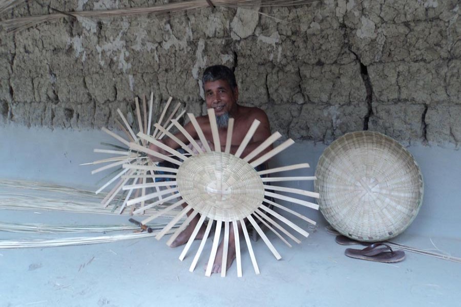 A bamboo craft artisan making different products at his homestead in Shibganj upazila of Bogura on Saturday  	— FE Photo