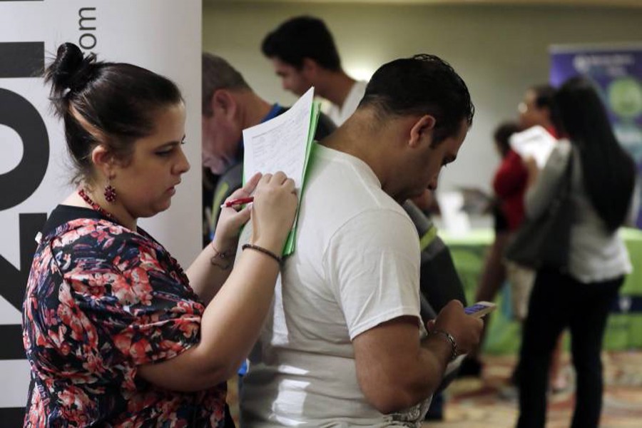 A file photo showing a woman filling out a job application at a JobNewsUSA job fair in Miami Lakes, Fla recently 	— AP