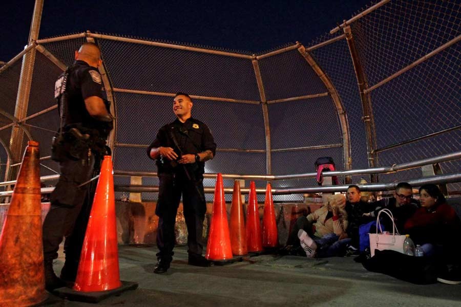 Border police look on as a group of Central Americans and Cubans hoping to apply for asylum wait at the border on an international bridge between Mexico and the US, in Ciudad Juarez, Mexico October 25, 2018. Reuters/File Photo