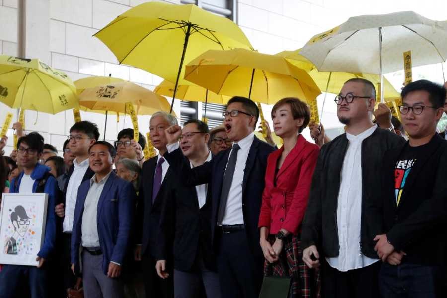 (L-R) Pro-democracy activists Chung Yiu-wa, Cheung Sau-yin, Lee Wing-tat, Chu Yiu-ming, Benny Tai, Chan Kin-man, Tanya Chan, Shiu Ka-chun and Raphael Wong pose outside a court in Hong Kong, China November 19, 2018 - Reuters