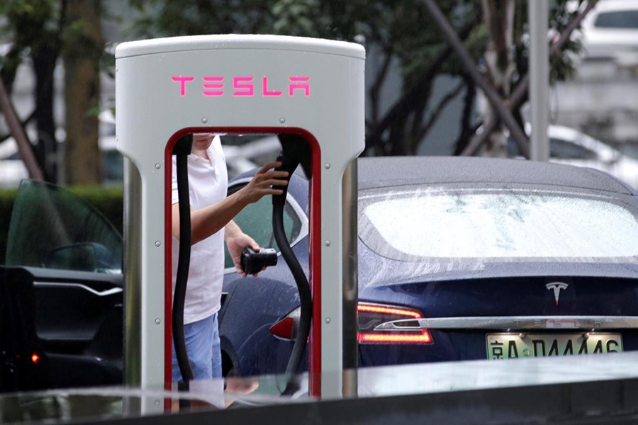 A man finishes charging his Tesla car at a charging point outside Tesla China headquarters in Beijing, China on July 11, 2018 — Reuters photo