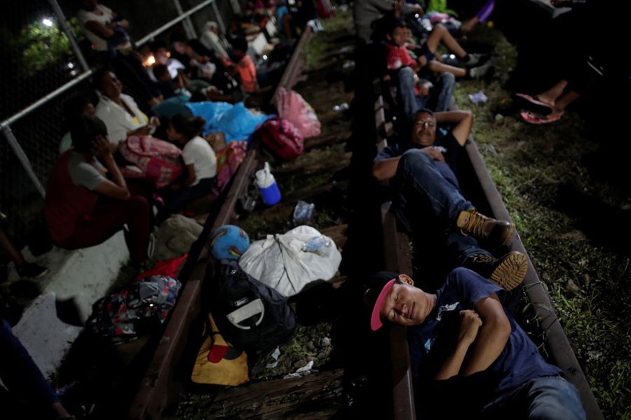 Honduran migrants, part of a caravan trying to reach the US, rest on the bridge that connects Mexico and Guatemala in Ciudad Hidalgo, Mexico, October 19, 2018 - Reuters