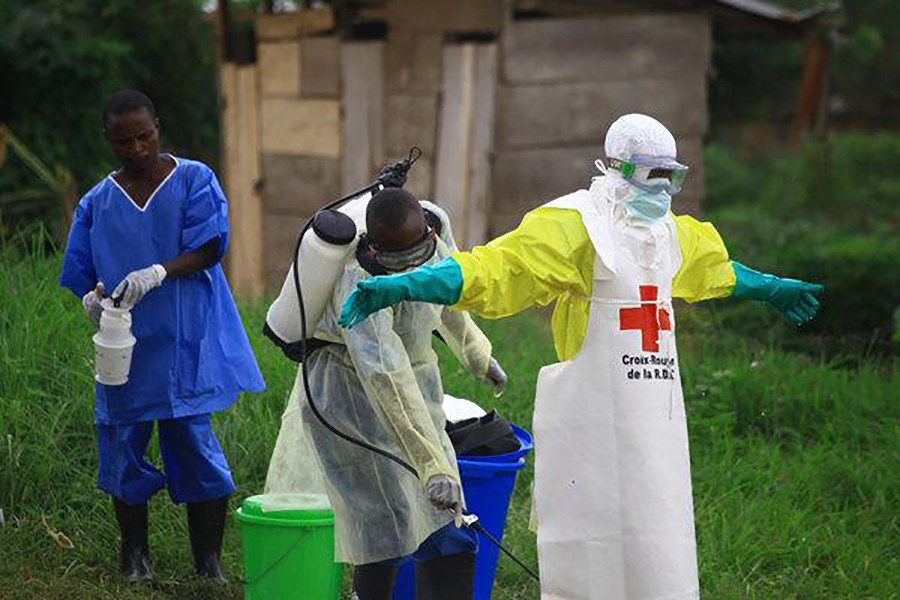 A health worker sprays disinfectant on his colleague after working at an Ebola treatment centre in Beni, Congo. AP Photo