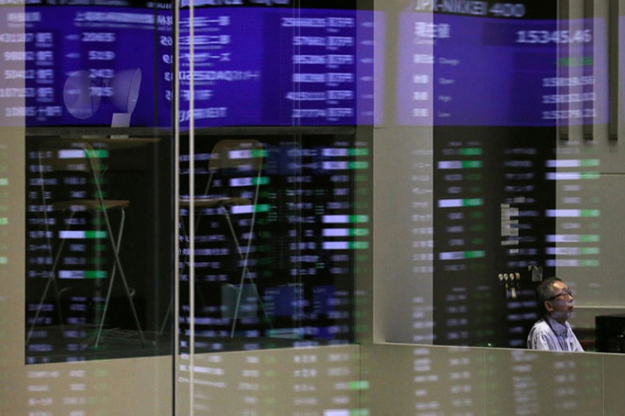 Market prices are reflected in a glass window at the Tokyo Stock Exchange (TSE) in Tokyo, Japan, February 6, 2018. Reuters/Files