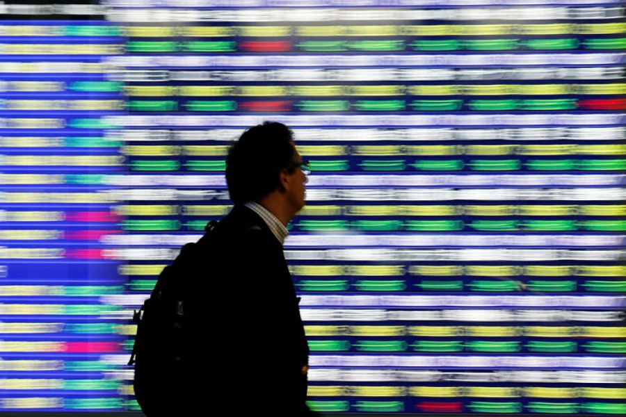 A man walks past an electronic stock quotation board outside a brokerage in Tokyo, Japan, November 13, 2018. Reuters/Files