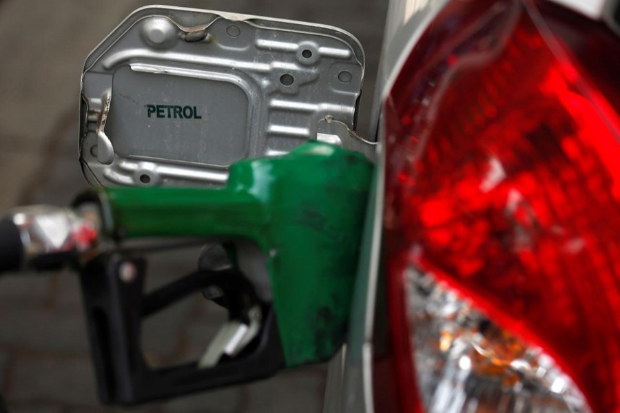 A worker holds a nozzle to pump petrol into a vehicle at a fuel station in Mumbai, India, May 21, 2018. Reuters/Files