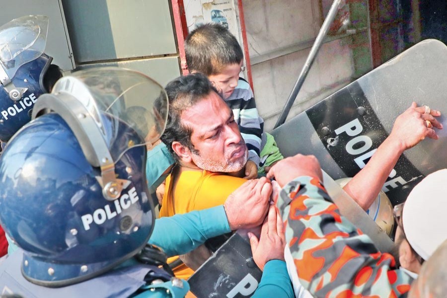 Police recovering the elder child from Nuruzzaman Kajal after he allegedly killed his younger son at Bangla Motor in the city on Wednesday - FE photo