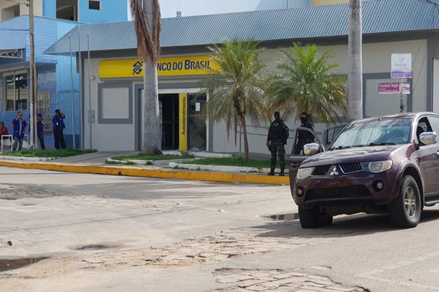 Policemen stand in front of the Banco do Brasil branch after a shootout between police and bank robbers, in Milagres, Brazil, December 7, 2018. Reuters