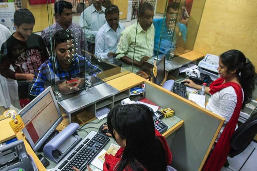 Indian expatriates crowd an exchange house to send money home. (Photo Credit: Gulf News)