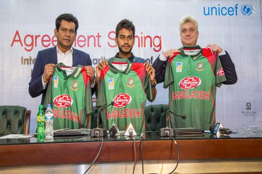 BCB Chief Executive Officer (CEO) Nizam Uddin Chowdhury, Unicef Bangladesh Representative Edouard Beigbeder and cricketer Mehidy Hasan Miraz holding the national cricket team’s match jerseys after signing an agreement at the BCB office in the city on Wednesday.