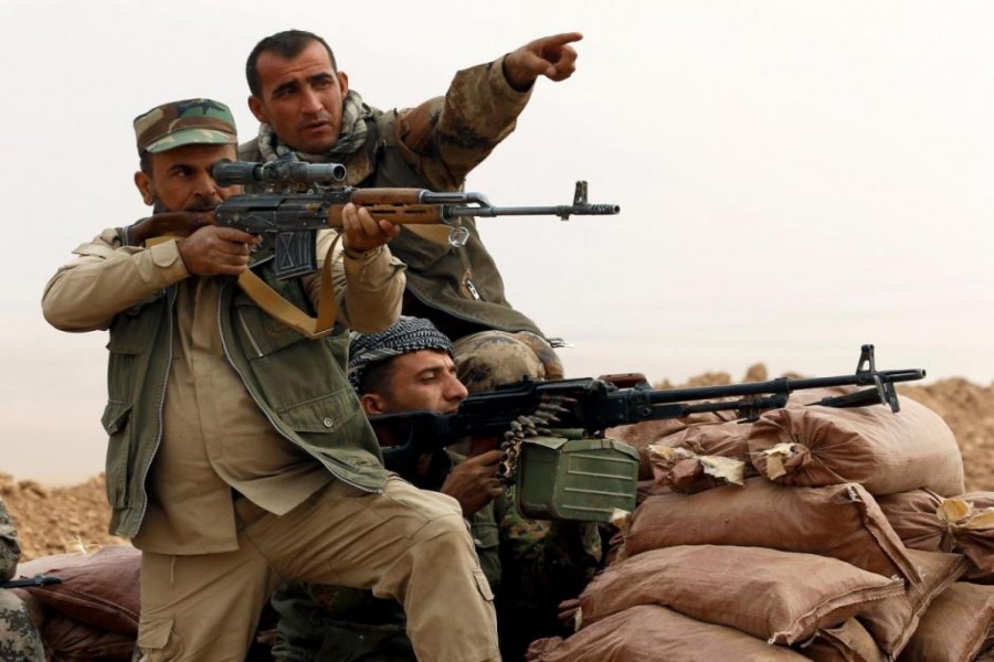 A Kurdish Peshmerga fighter aims to fire during a battle with Islamic State militants at Topzawa village, near Bashiqa, near Mosul, Iraq October 24, 2016 - Reuters