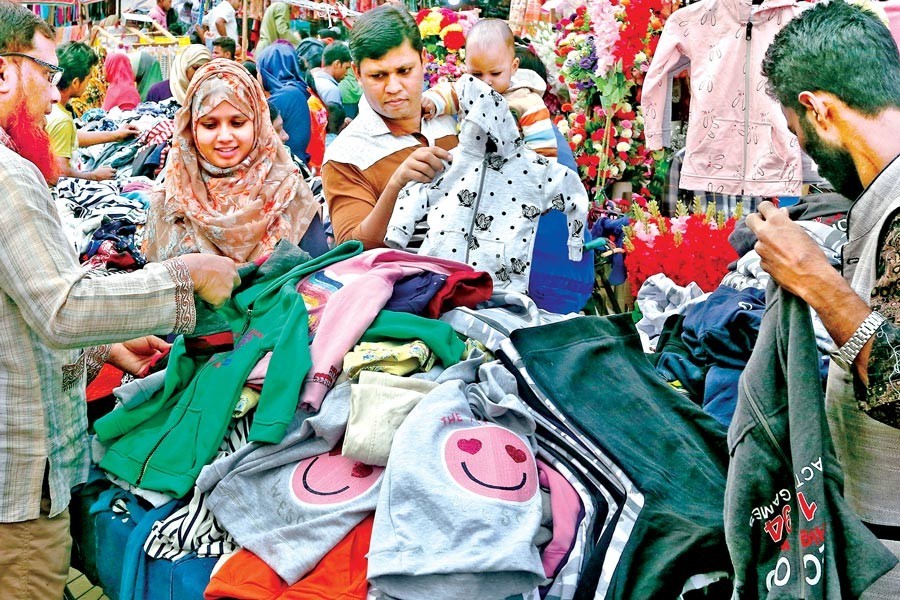 Sales of winter clothes have picked up with the fall of temperature in the country. The photo shows people buying warm clothes from a footpath hawker at Mirpur-10 in the city on Thursday — FE photo