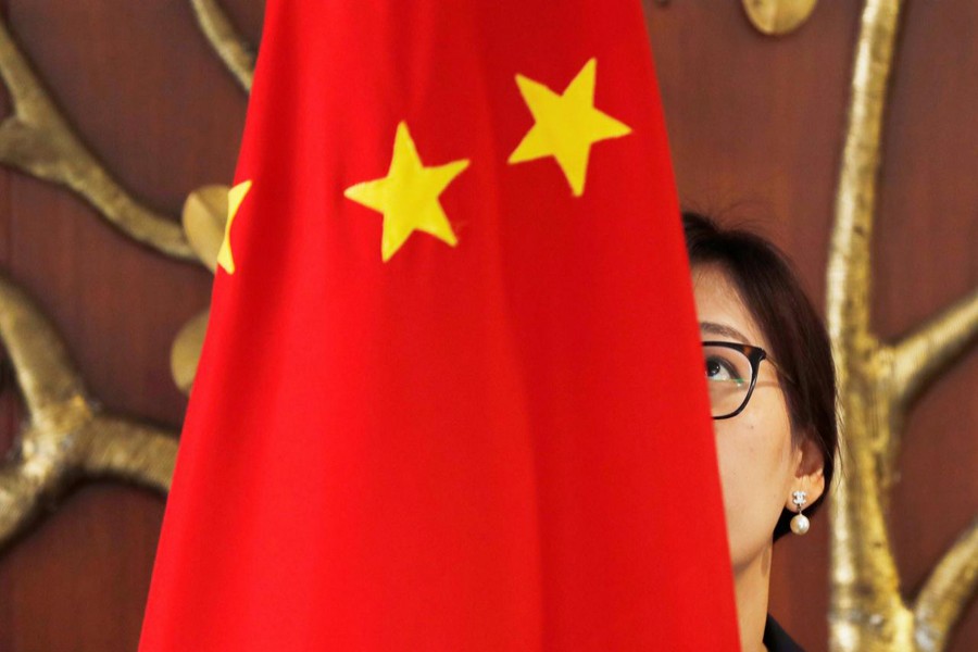 A Chinese official adjusts a Chinese flag before the start of a meeting between Foreign Minister Wang Yi and Indian Foreign Minister Sushma Swaraj in New Delhi, India, December 21, 2018. Reuters