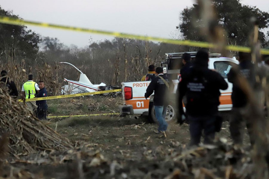 Police and rescue personnel stand at the scene where the helicopter transporting Martha Erika Alonso, governor of the state of Puebla, and her husband Senator Rafel Moreno Valle crashed, in Coronango, Puebla Mexico, December 24, 2018 - REUTERS/Imelda Medina