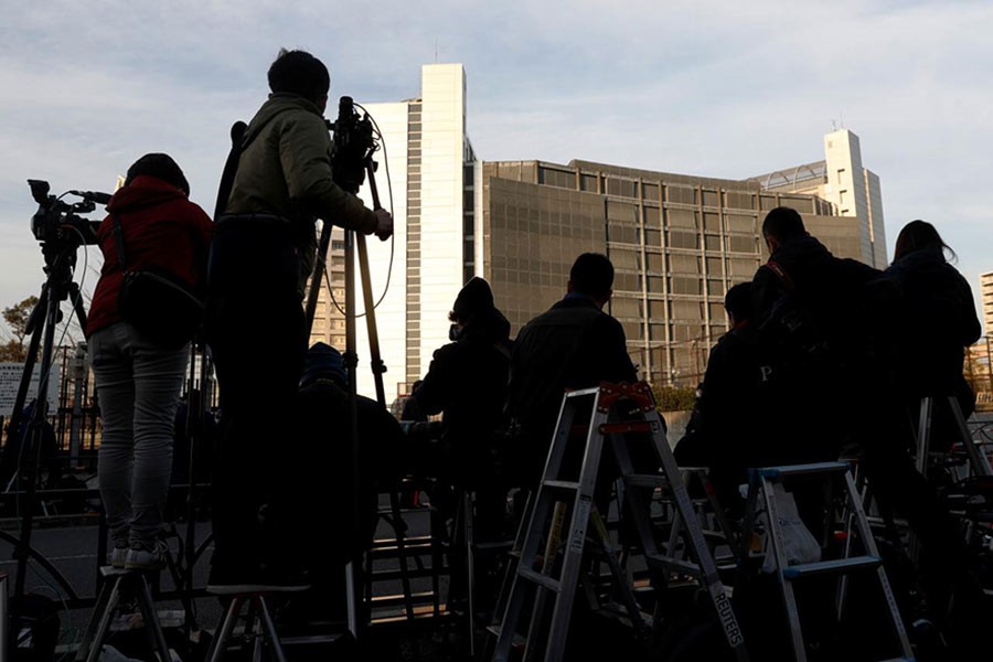 Members of media crews are seen on step ladders in front of the Tokyo Detention Centre, where Nissan's arrested chairman Carlos Ghosn and a former Nissan executive Greg Kelly are being held, in Tokyo of Japan on Tuesday. -Reuters Photo