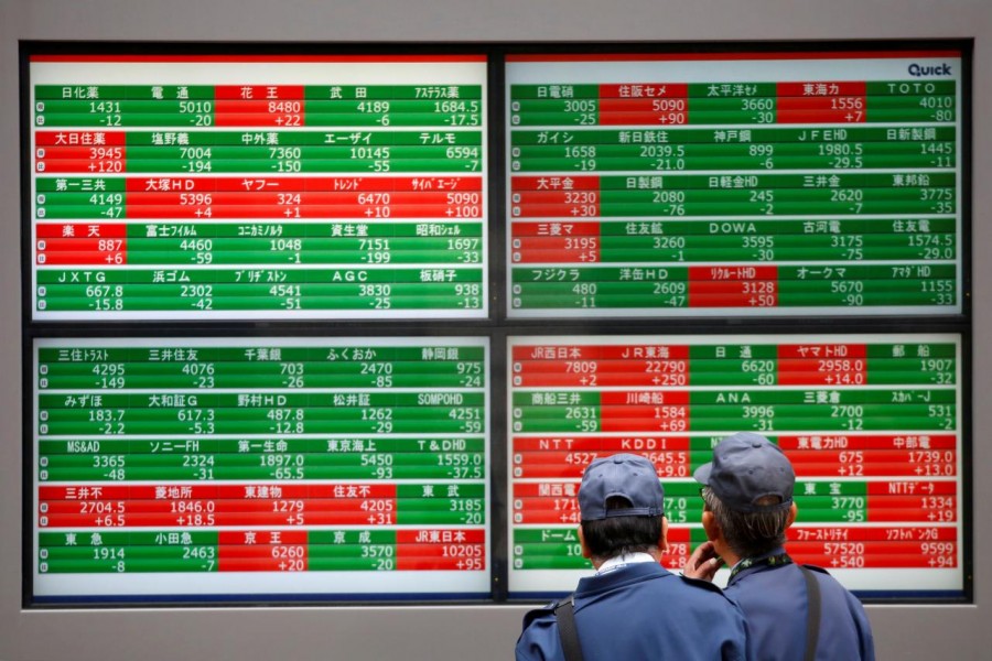 Men look at stock quotation boards outside a brokerage in Tokyo, Japan, December 5, 2018. Reuters/Files