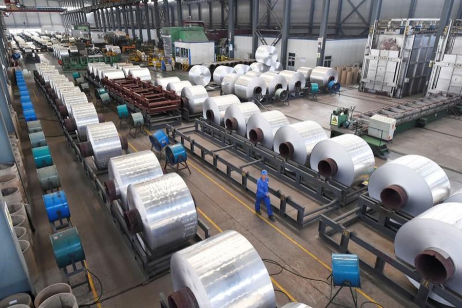 Workers are seen next to aluminium rolls at a plant in Binzhou, Shandong province, China September 13, 2018. Reuters/Files