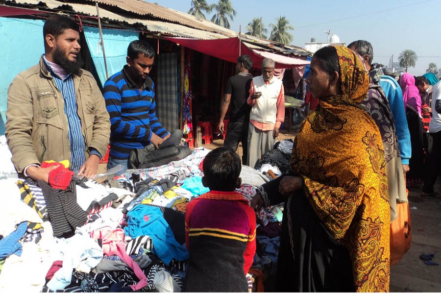 Cold-hit people from different areas purchasing warm clothes from Shapla Super Market in Sadar Upazila of Bogura district. 	— FE Photo