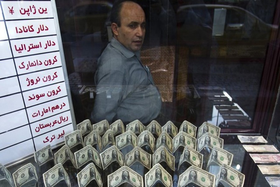 An exchange currency dealer sits at his shop as he waits for customers in Tehran's business district, October 24, 2011. Reuters/Files