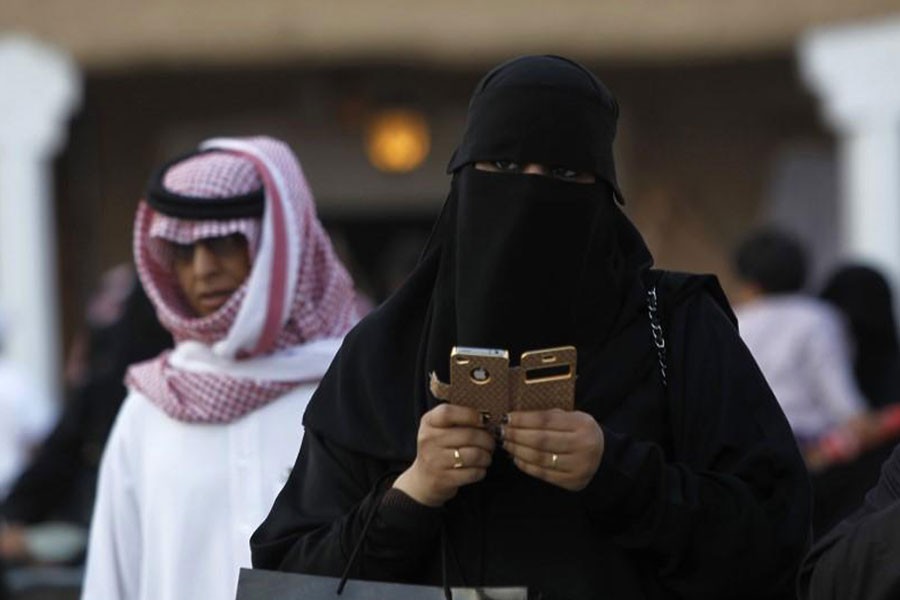 A woman using an iPhone visits the 27th Janadriya festival on the outskirts of Riyadh in this February 13, 2012 file photo - REUTERS/Fahad Shadeed/Files