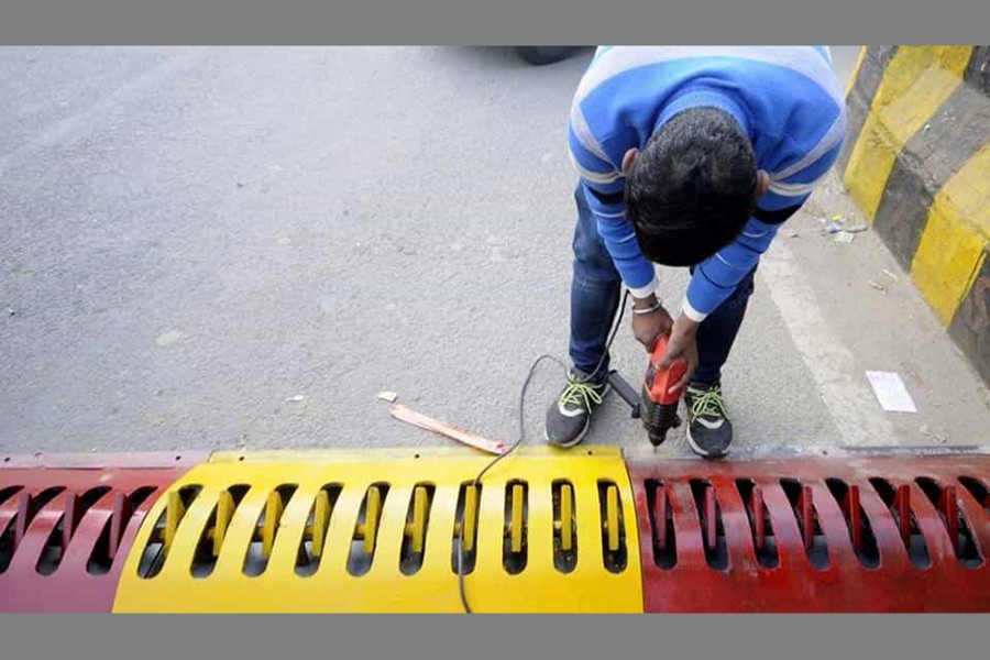 A worker installs tyre killers in India’s Noida city to check wrong side driving. Photo: Hindustan Times