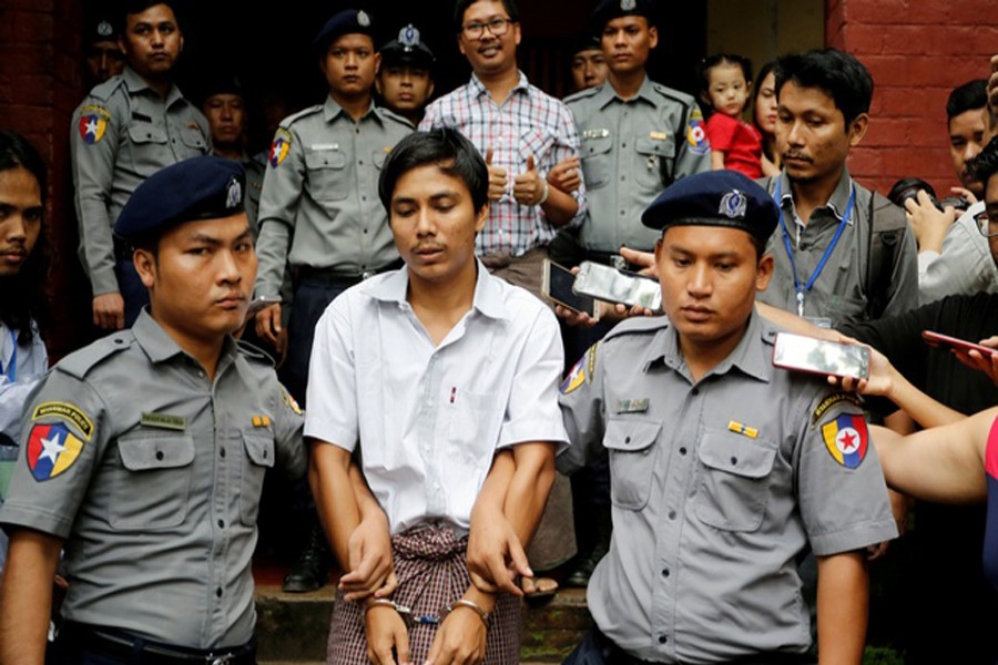 Detained Reuters journalist Kyaw Soe Oo and Wa Lone are escorted by police as they leave after a court hearing in Yangon, Myanmar, August 20, 2018. Reuters/Files