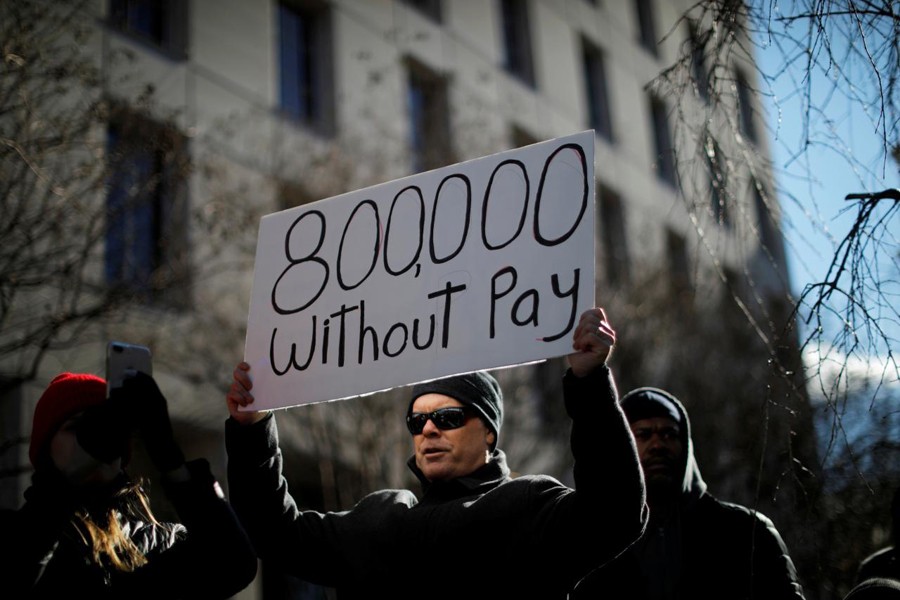 A demonstrator holds a sign, signifying hundreds of thousands of federal employees who won’t be receiving their paychecks as a result of the partial government shutdown, during a “Rally to End the Shutdown” in Washington, US, January 10, 2019. Reuters