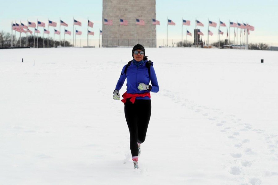 A jogger makes her way through snow at the Washington Monument following a winter storm, January 14, 2019. Reuters/File Photo