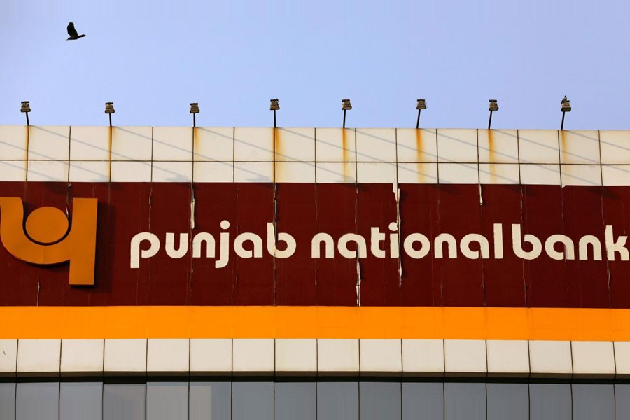 A bird flies past the logo of Punjab National Bank installed on the facade of its office in Mumbai, India February 21, 2018 - Reuters file photo